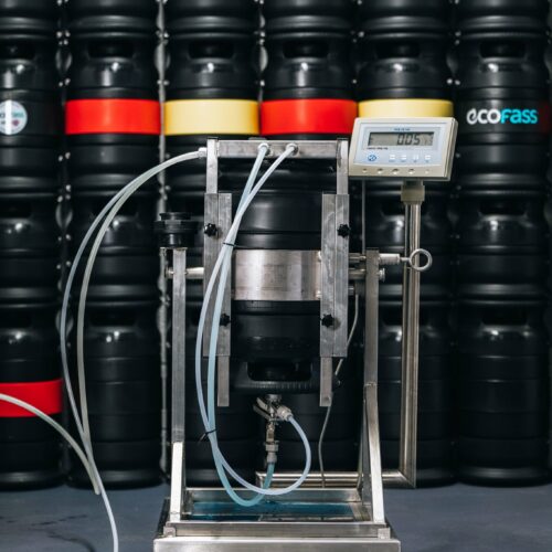Inverted ECOFASS keg on its inverter stand during filling, control scale in the background