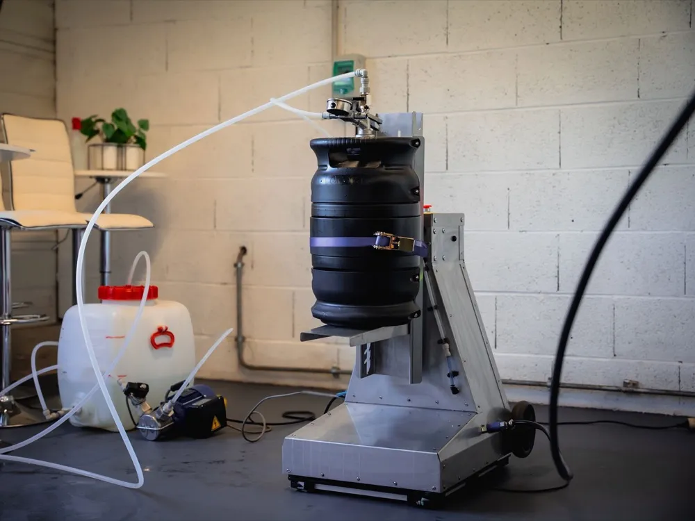Stainless-steel ECOFASS inverter stand: keg strapped upside down on the wheeled frame, pump and rinsing can on the floor